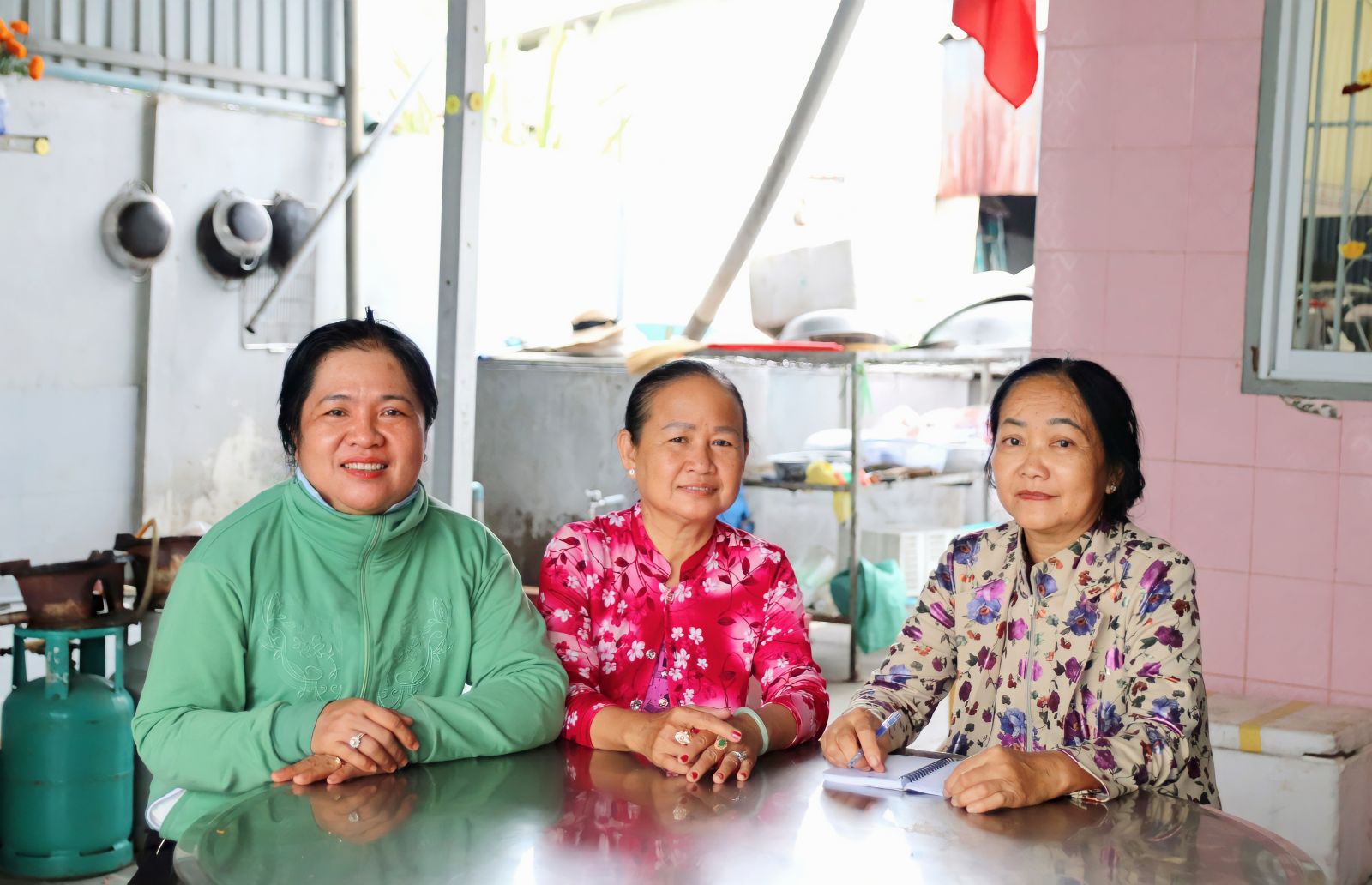 Từ năm 2018 đến nay, bà Nguyễn Thị Diệp (bìa phải), ngụ khu phố Thủ Tửu 2, phường Tân Khánh, kiêm thêm công việc “bếp chính” cho nhóm (Trong ảnh: Bà Diệp cùng chị em liệt kê các nguyên liệu chuẩn bị cho 200 suất ăn)