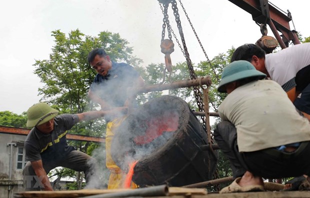 To make the 300-kg bronze drum, bronze blocks are completely melted into liquid and then slowly poured into a mould. (Photo: VNA)