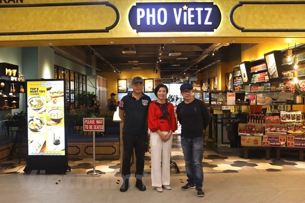 Ton Ngoc Hiep (third from left) in front of his restaurant (Photo: VNA)