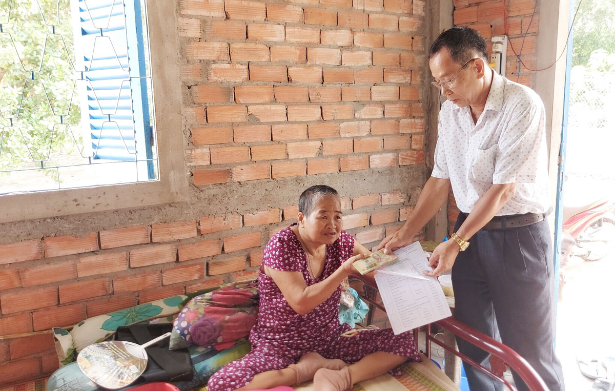 Phó Chủ tịch Hội Chữ thập đỏ tỉnh - bác sĩ Hồ Văn Cưng trao tiền cho bà Huỳnh Thị Nữa từ chương trình Vượt qua hiểm nghèo