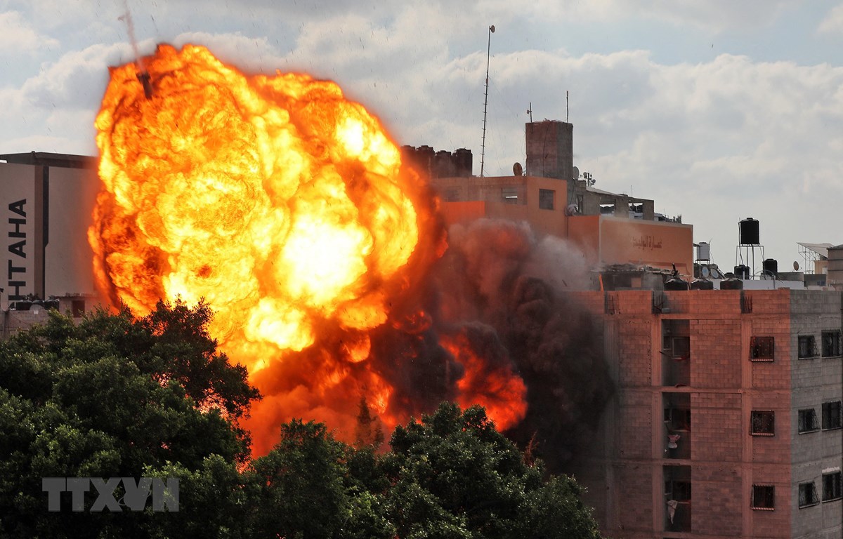 Quả cầu lửa bốc lên khi toà nhà Al-Walid ở thành phố Gaza trúng rocket trong cuộc oanh tạc của máy bay Israel ngày 13/5/2021. (Ảnh: AFP/TTXVN)