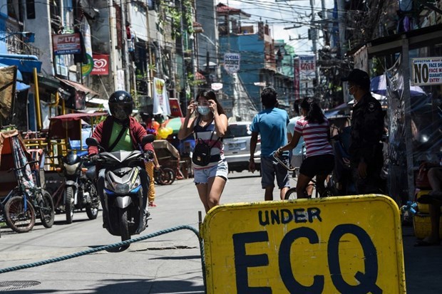 World Bank lowers Philippine economic growth forecast for 2021 A policeman (right) monitors people at the entrance to a neighbourhood under strict quarantine measures in Pasay City, suburban Manila (Photo: AFP)