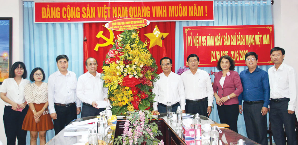 Đồng chí Nguyễn Văn Được (người đứng giữa) đến thăm những người làm báo Báo Long An. Ảnh: Thu Ngân