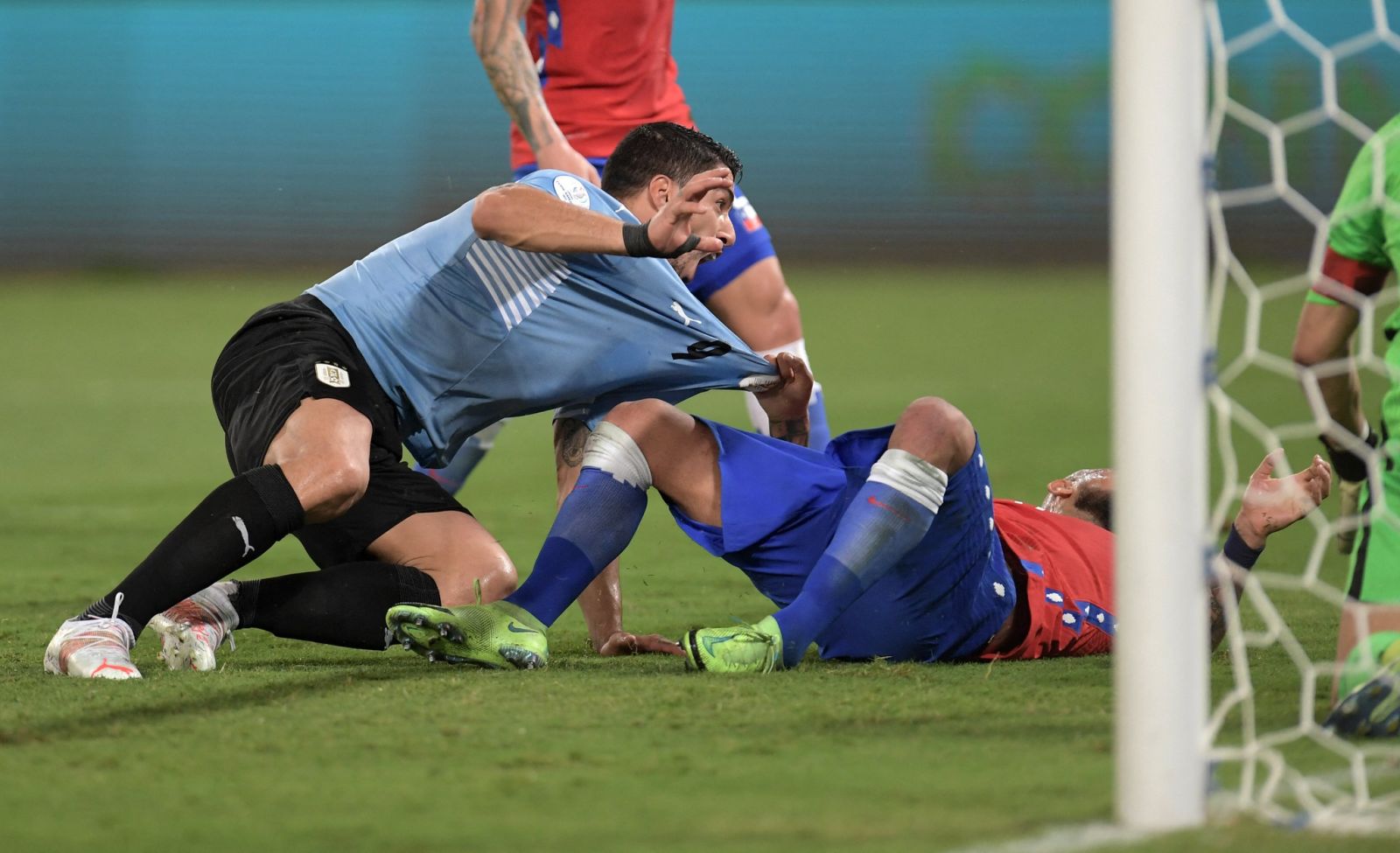 Suarez tinh quái đè Arturo Vidal ghi bàn gỡ hòa cho tuyển Uruguay. AFP