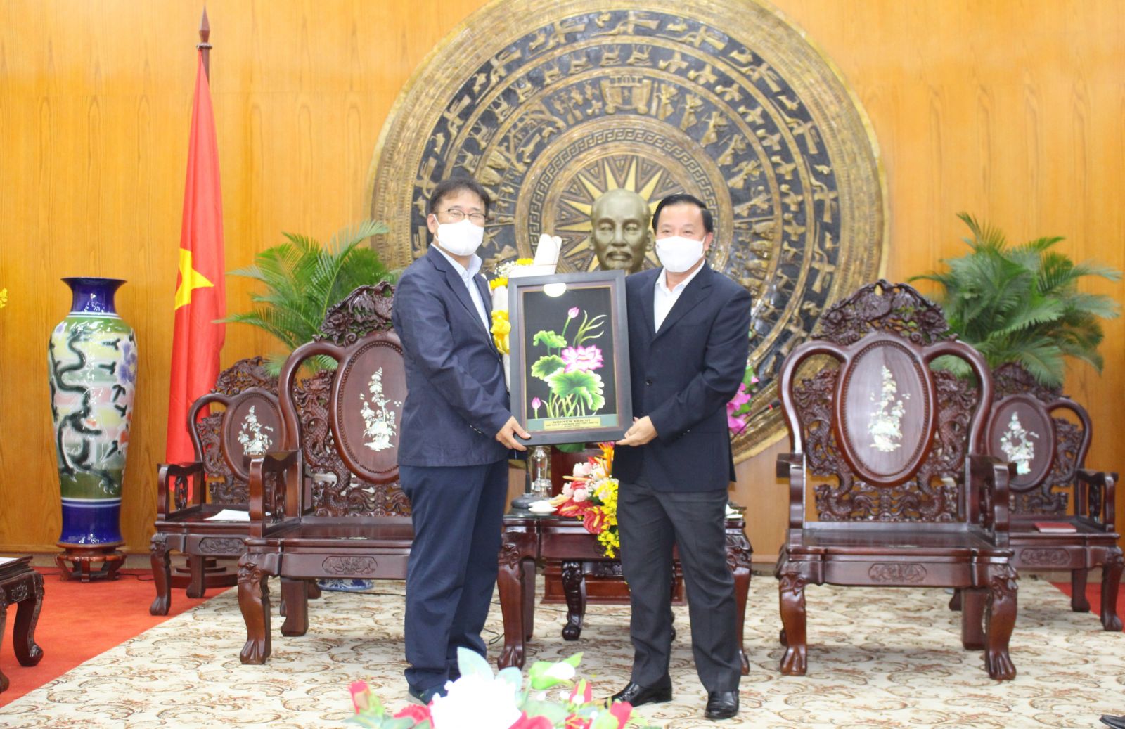 Chairman of Provincial People's Committee – Nguyen Van Ut (R) presents flowers and souvenirs to leaders of AJ TOTAL Vietnam Co., Ltd.