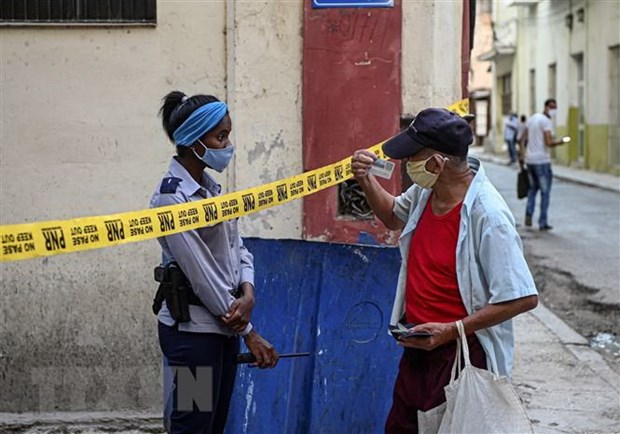 Cảnh sát gác tại một khu vực bị phong tỏa sau khi phát hiện ca mắc COVID-19 tại La Habana, Cuba. (Ảnh: AFP/TTXVN)