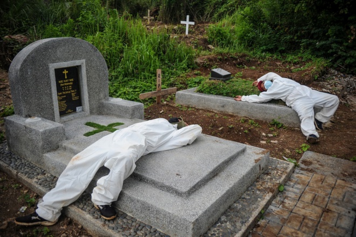 Các phu mộ ở Indonesia phải làm việc ngày đêm vì số người chết tăng nhanh trong đợt bùng phát dịch mới. (Ảnh: Reuters).