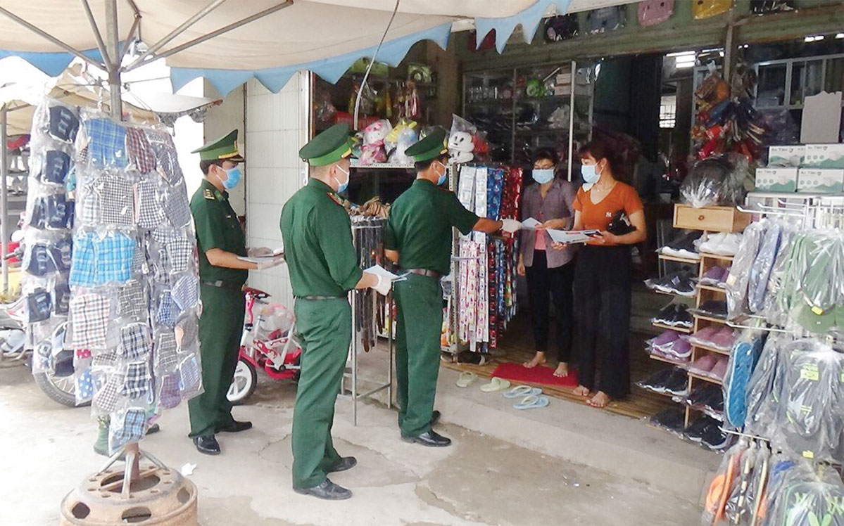 Ấm tình quân - dân trong mùa dịch Cán bộ, chiến sĩ Đồn Biên phòng Cửa khẩu Quốc tế Bình Hiệp phát tờ rơi tuyên truyền phòng, chống dịch đến từng hộ dân