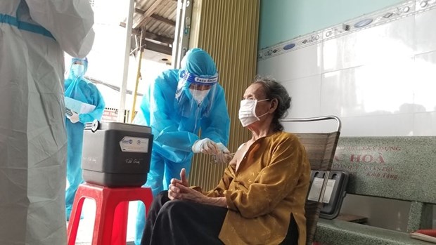 Lực lượng y tế tại Thành phố Hồ Chí Minh đi từng ngõ, gõ từng nhà tiêm vaccine COVID-19 cho người cao tuổi. (Ảnh: PV/Vietnam+)