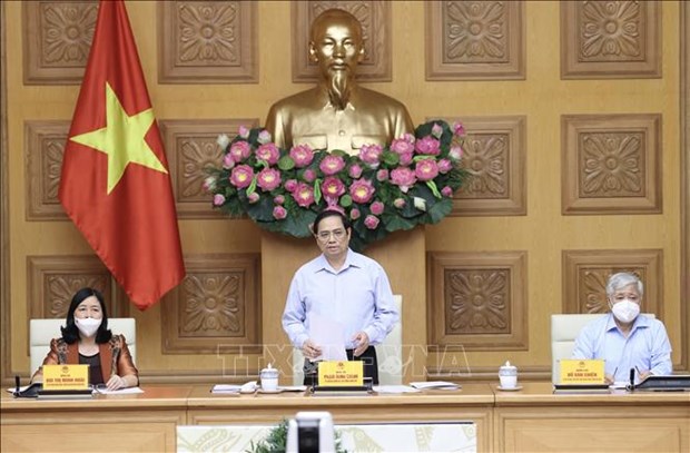 PM asks for people's further engagement in COVID-19 fight Prime Minister Pham Minh Chinh (centre) chairs the meeting (Photo: VNA)