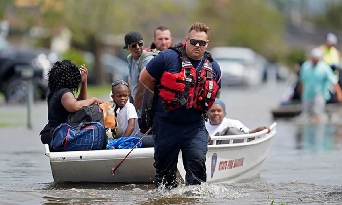 Nhân viên cứu hỏa bang Louisiana sơ tán người mắc kẹt vì lũ lụt do bão Ida gây ra tại thành phố New Orleans ngày 30/8. Ảnh: AP.