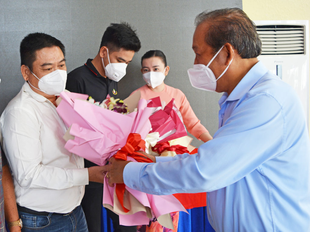 Former Permanent Deputy PM - Truong Hoa Binh presents flowers to businesses accompanying the local government in the prevention and control of the Covid-19 epidemic