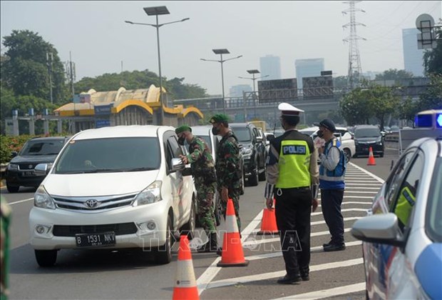 Indonesia adjusts COVID-19 restrictions according to localities Police monitor travel on a road in Indonesia. (Source: Xinhua/VNA)