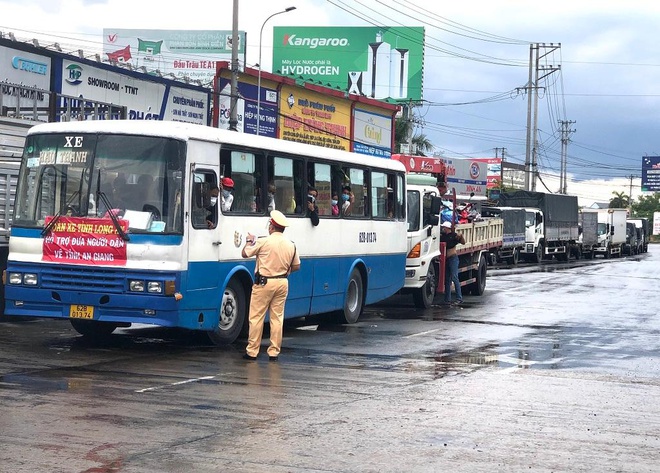 Người dân tỉnh An Giang được lực lượng chức năng tỉnh Long An đưa về đến cửa ngõ tỉnh An Giang chiều ngày 1/10. TRẦN NGỌC