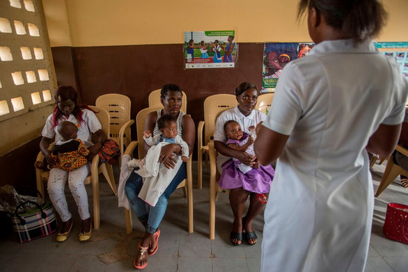 Y tá giải thích về vắc xin sốt rét với các bà mẹ có con nhỏ tại Ghana - Ảnh: AFP