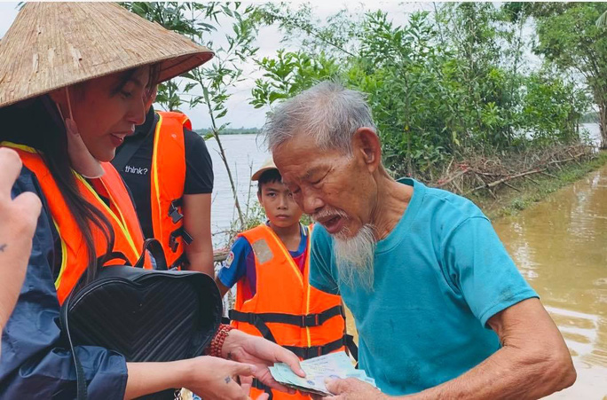 Ca sĩ Thủy Tiên trao tiền cho người dân bị ảnh hưởng bởi lũ lụt tại miền Trung (ảnh Facebook ca sĩ Thủy Tiên)