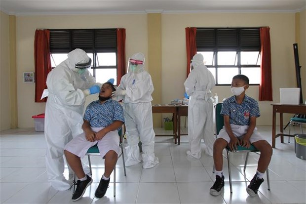 Nhân viên y tế lấy mẫu xét nghiệm COVID-19 cho học sinh tại Surakarta, Trung Java, Indonesia. (Ảnh: THX/TTXVN)