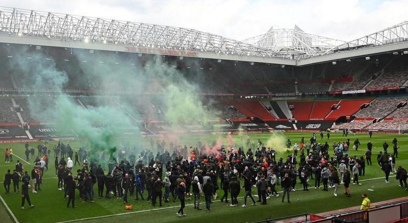 CĐV M.U xâm chiếm sân Old Trafford khiến trận M.U và Liverpool hồi tháng 5 phải hoãn. AFP