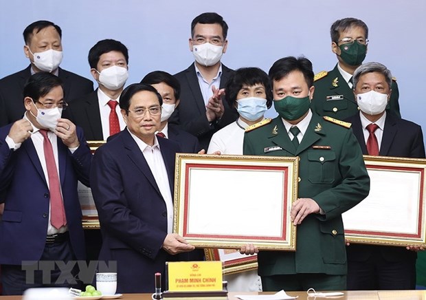 Thủ tướng Phạm Minh Chính trao Bằng khen cho các cá nhân tiêu biểu, xuất sắc trong công tác phòng, chống dịch COVID-19. (Ảnh: Dương Giang/TTXVN)