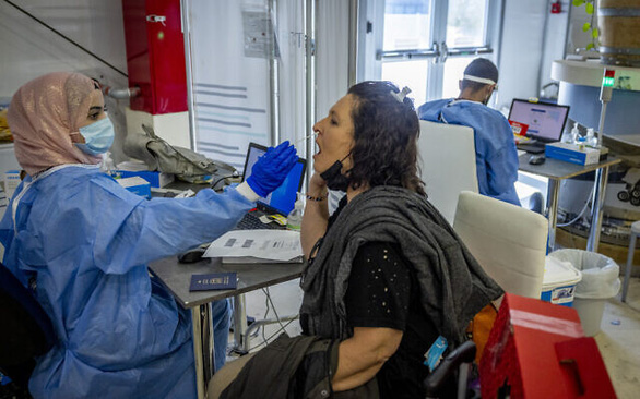 Nhân viên y tế lấy mẫu xét nghiệm COVID-19 cho một phụ nữ từ nước ngoài quay về tại sân bay quốc tế Ben Gurion (Israel) ngày 20/9/2021 - Ảnh: TIMES OF ISRAEL/FLASH90