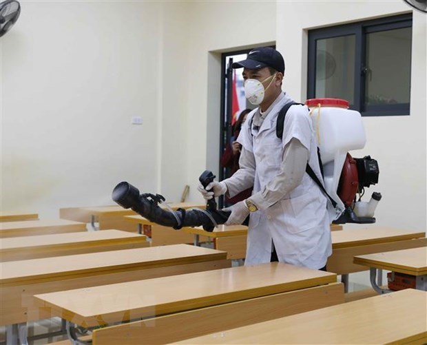 Education Ministry issues set of safety criteria in COVID-19 prevention and control Spraying disinfectants in a classroom (Photo: VNA)