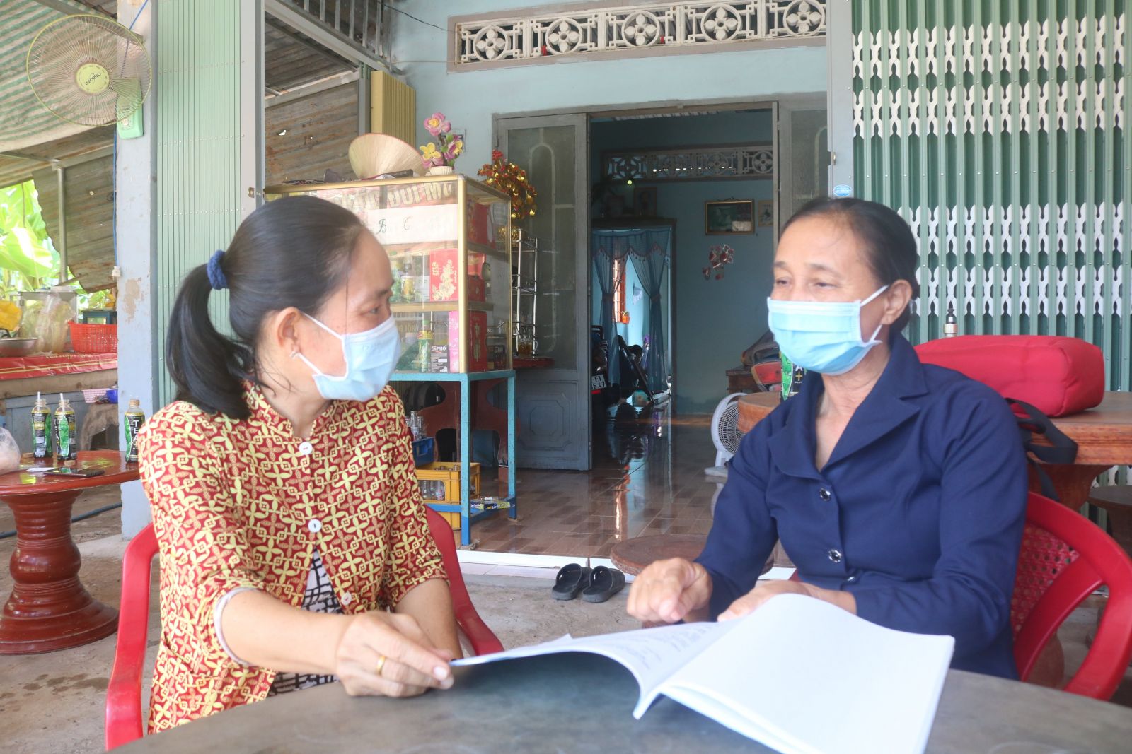 Bà Nguyễn Thị Thường (bên phải) tuyên truyền người dân về lợi ích khi thực hiện kế hoạch hóa gia đình