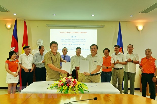 Đại diện Công ty King Technologies Co.,Ltd (OpenNet) và Quỹ phát triển nguồn nhân lực trong cộng đồng người gốc Việt tại Campuchia ký thỏa thuận tài trợ học bổng cho sinh viên người gốc Việt. (Ảnh: Trần Long/TTXVN)