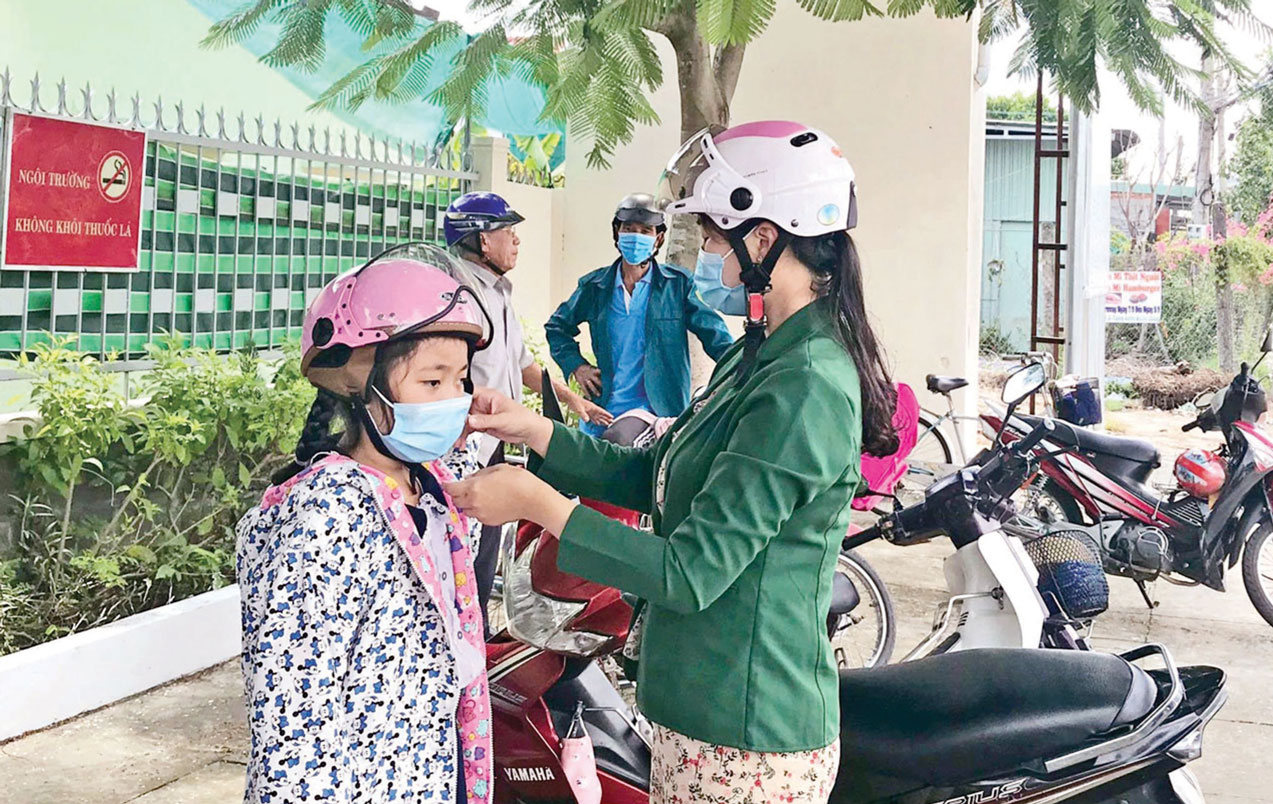 Đội nón bảo hiểm cho con trước khi lưu thông bằng xe môtô  (Ảnh tư liệu)