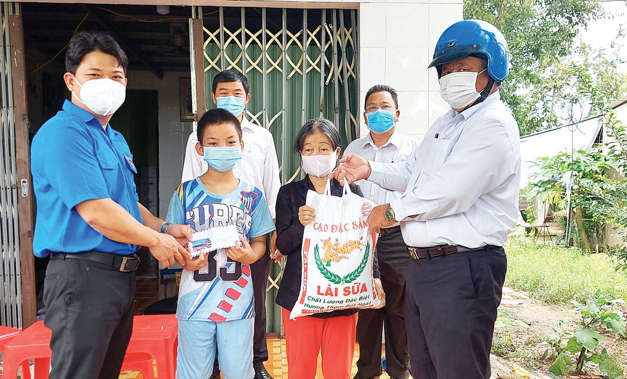 Chủ tịch UBMTTQ Việt Nam TP.Tân An - Lê Thành Phước (bìa phải) trao quà cho người dân gặp khó khăn do ảnh hưởng của dịch bệnh