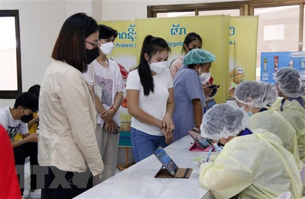 Học sinh tại Lào chuẩn bị tiêm vacicne COVID-19. (Ảnh: Phạm Kiên/TTXVN)