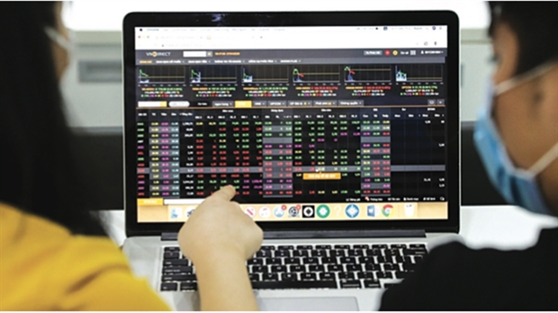 Two investors looking at a stock trading board on a laptop. (Photo: vneconomy.vn)