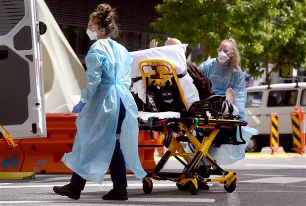 Nhân viên y tế chuyển bệnh nhân COVID-19 tại bệnh viện ở Melbourne (Australia). (Ảnh: AFP/TTXVN)