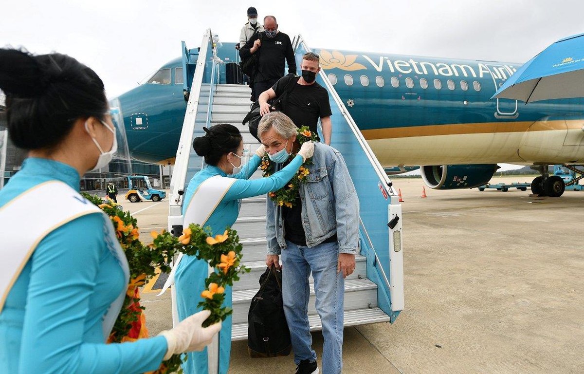 Những hành khách quốc tế trên chuyến bay thí điểm đón du khách quốc tế đến Việt Nam. (Ảnh: CTV/Vietnam+)