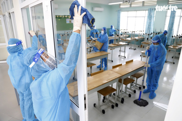 Giáo viên và nhân viên Trường THCS Nguyễn Văn Tố (Q.10, TP.HCM) đang làm vệ sinh và khử khuẩn phòng học chuẩn bị đón học sinh đi học trở lại - Ảnh: NHƯ HÙNG
