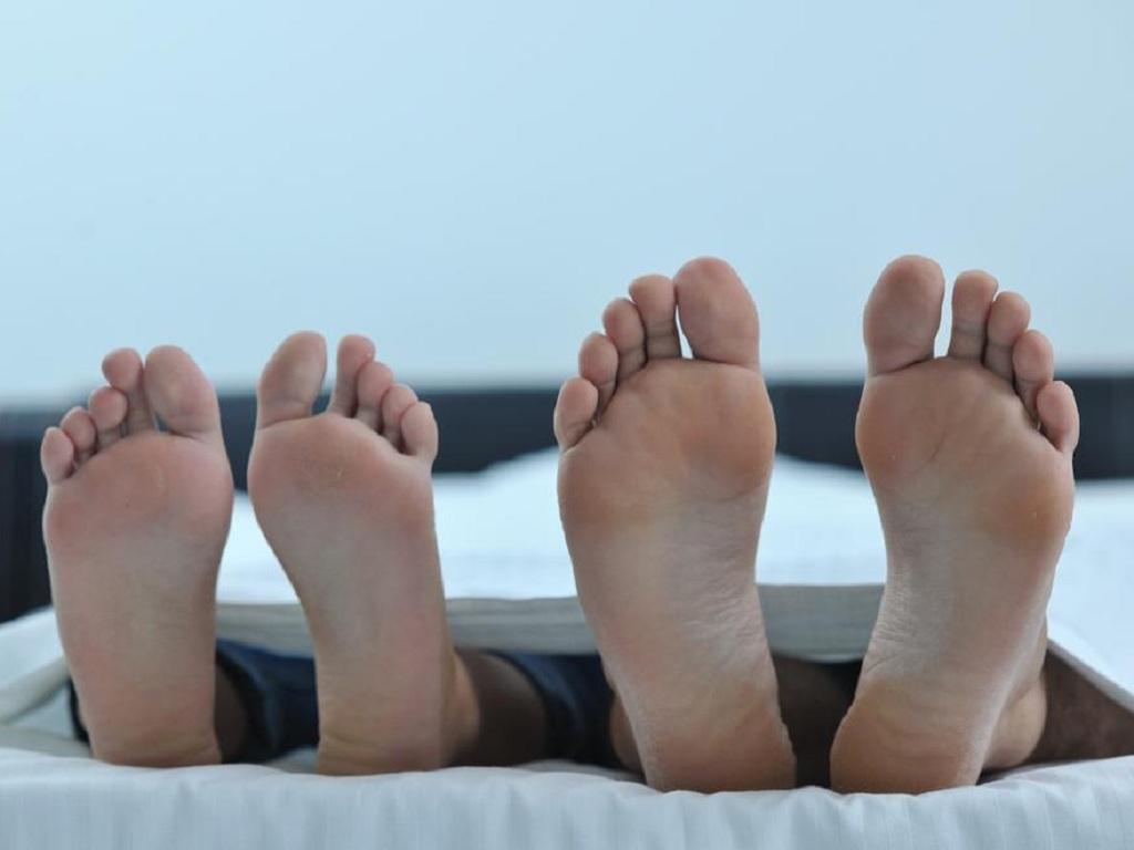 Đưa chân ra khỏi mền có thể giúp dễ chìm vào giấc ngủ hơn. Ảnh SHUTTERSTOCK