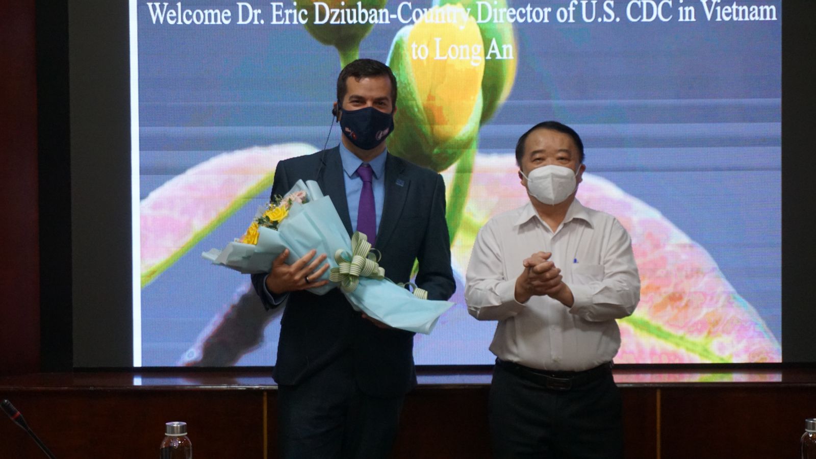 Giám đốc Sở Y tế Long An - BS CKII Huỳnh Minh Phúc (bên phải) tặng hoa, chào mừng Giám đốc CDC Hoa Kỳ tại Việt Nam - Tiến sĩ Eric Dziuban tham dự Lễ khởi động sự kiện “Điều trị ARV là dự phòng” tại Long An