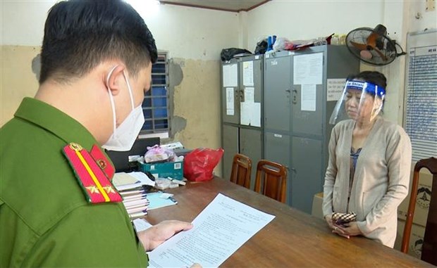 Nguyễn Thị Kim Hạnh (tức Mười Tường) nghe công an đọc quyết định khởi tố. (Ảnh: TTXVN)