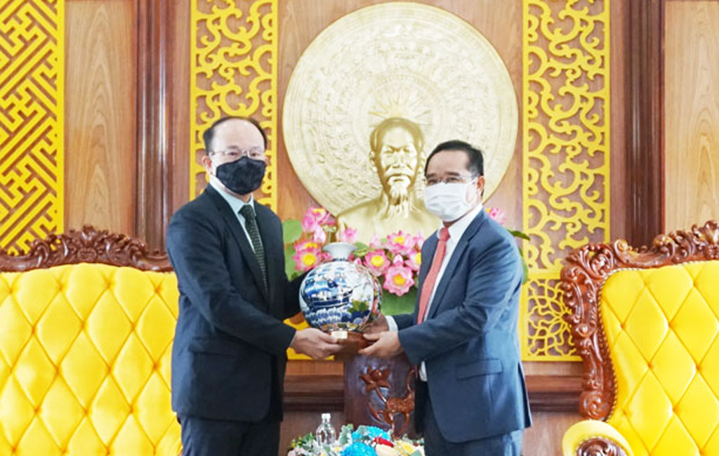 Secretary of the Provincial Party Committee, Chairman of the Provincial People's Council - Nguyen Van Duoc (R) presents souvenirs to the Consulate General of Singapore in Ho Chi Minh City