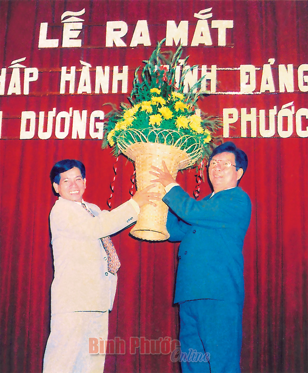 Bí thư Tỉnh ủy Sông Bé Nguyễn Minh Triết trao tặng lẵng hoa của Ban Chấp hành Đảng bộ Sông Bé chúc mừng Ban Chấp hành Đảng bộ tỉnh Bình Dương - Bình Phước. Ảnh tư liệu