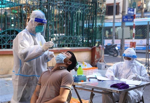 Nhân viên y tế lấy mẫu xét nghiệm sàng lọc COVID-19 cho người dân trong khu vực bị phong tỏa tại Hà Nội. (Ảnh minh họa: Hoàng Hiếu/TTXVN)
