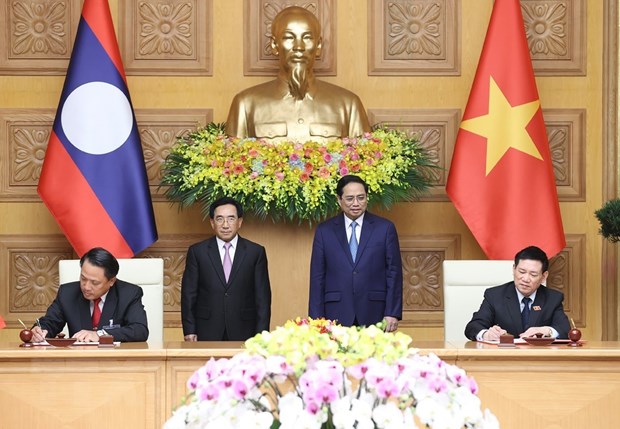 Thủ tướng Phạm Minh Chính và Thủ tướng Lào Phankham Viphavanh chứng kiến lễ ký kết văn kiện hợp tác giữa Bộ Tài chính hai nước. (Ảnh: Dương Giang/TTXVN)