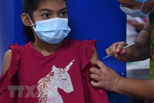 Nhân viên y tế tiêm vaccine ngừa COVID-19 cho trẻ em trong độ tuổi từ 6-11 tại San Salvador, El Salvador. (Ảnh: AFP/TTXVN)