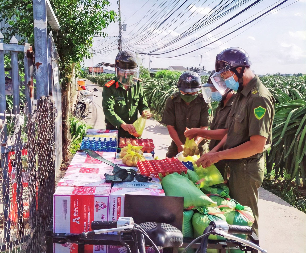 Đại úy Nguyễn Thái Châu (bìa trái) phân chia thực phẩm hỗ trợ người dân trong đại dịch
