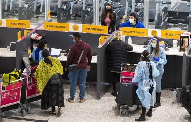 Hành khách đeo khẩu trang phòng lây nhiễm COVID-19 tại sân bay quốc tế Toronto ở Mississauga, Ontario (Canada). (Ảnh: THX/TTXVN)
