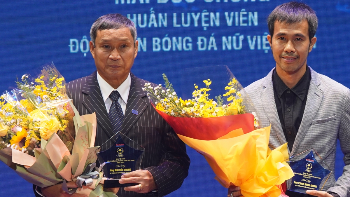 HLV Mai Đức Chung và HLV Phạm Minh Giang nhận kỷ niệm chương và hoa trong Lễ trao giải Quả bóng Vàng Việt Nam 2021 (Ảnh: BTC).
