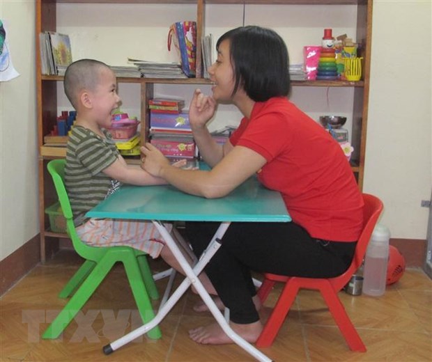 Giáo viên can thiệp, trị liệu và hỗ trợ hòa nhập cho trẻ tự kỷ ở Trung tâm jỗ trợ phát triển giáo dục hòa nhập Thiên thần nhỏ, Ninh Bình . (Ảnh: Thùy Dung/TTXVN)