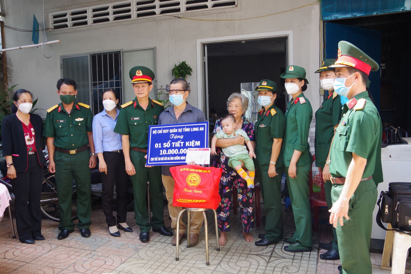Đại tá Nguyễn Minh Tấn - Phó Chính ủy Bộ Chỉ huy Quân sự tỉnh, tặng sổ tiết kiệm cho trẻ em mồ côi do Covid-19