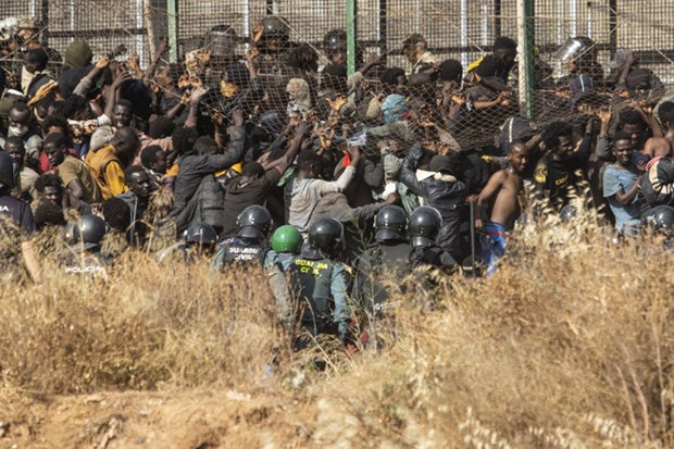 Những người di cư đã cố gắng phá hàng rào ngăn cách giữa Maroc và vùng lãnh thổ Melilla, buộc lực lượng chức năng Maroc phải can thiệp, dẫn đến vụ giẫm đạp. (Nguồn: AP)