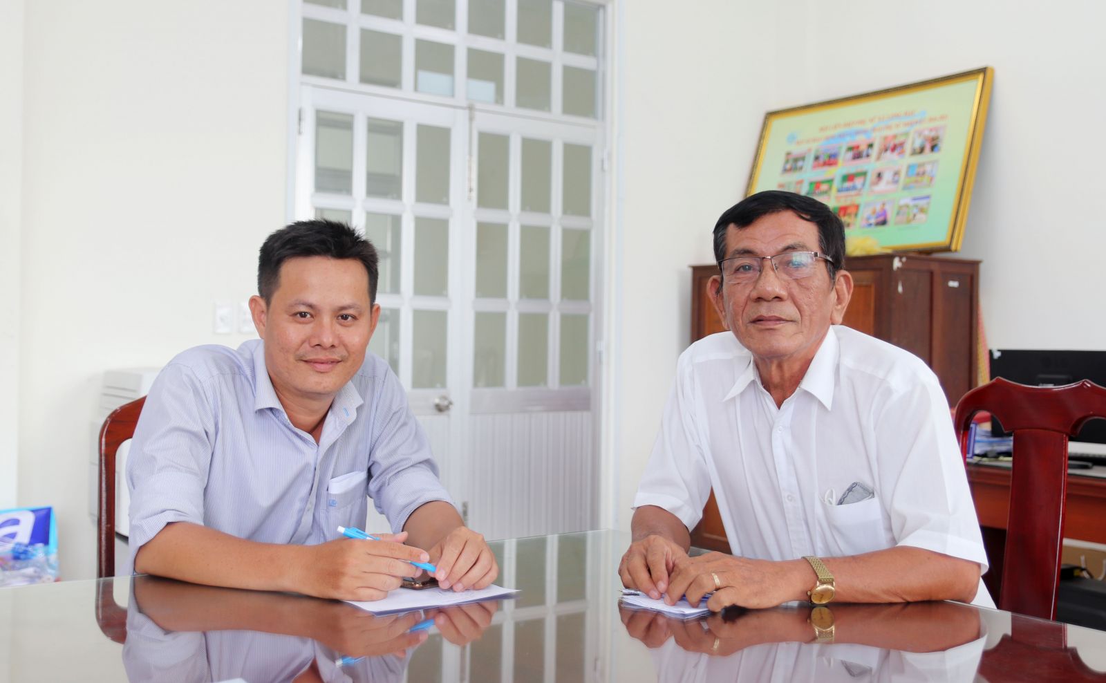 Ông Nguyễn Hữu Phúc (bên phải) trao đổi công việc cùng Chủ tịch UBMTTQ Việt Nam xã Long Hậu - Hồ Minh Trung