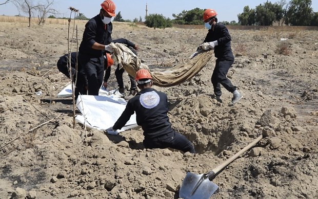 Khai quật một ngôi mộ tập thể ở Raqqa, Syria. (Ảnh: AP)